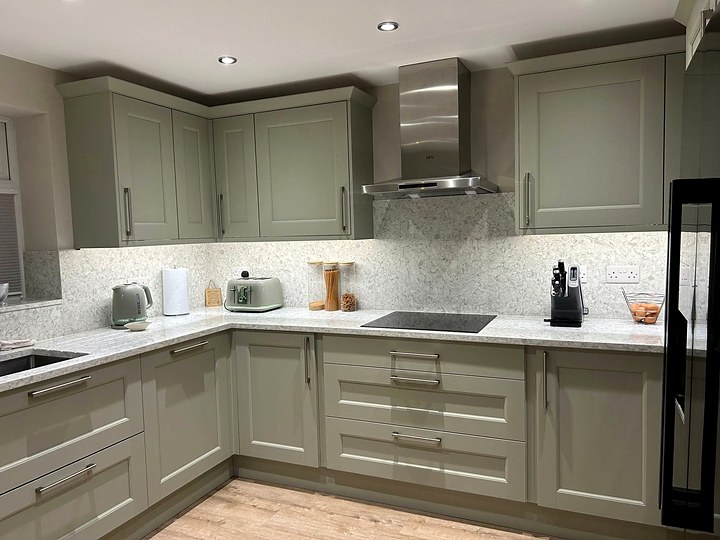 Sage green kitchen with recessed downlights and LED under-cabinet lighting over the worktops